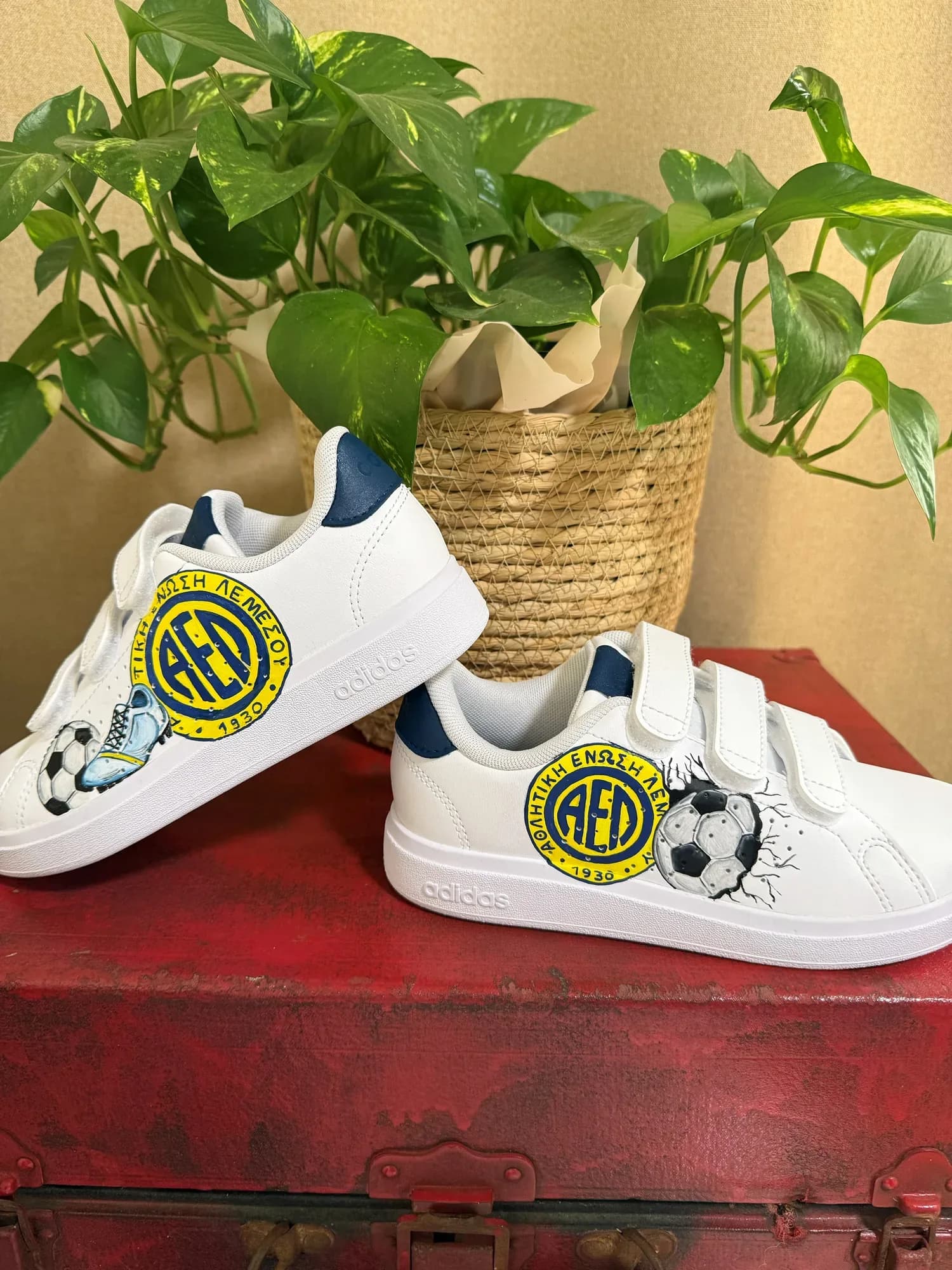 Λευκά παιδικά sneakers με velcro και ζωγραφισμένο το έμβλημα της ΑΕΛ, μπάλα και ποδοσφαιρικό παπούτσι